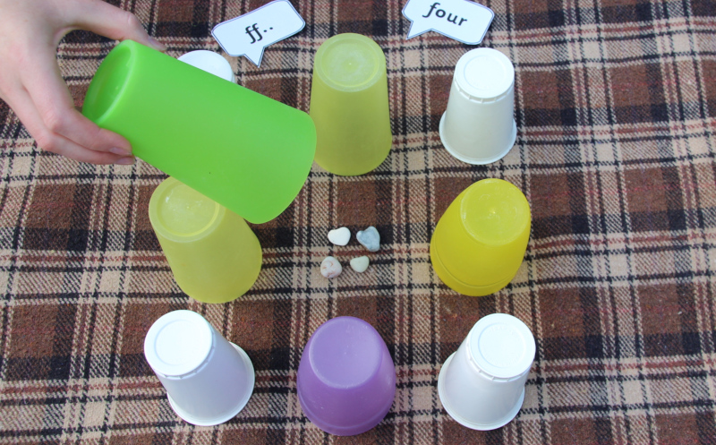 Nine pots each hiding a number of pebbles for subitising game