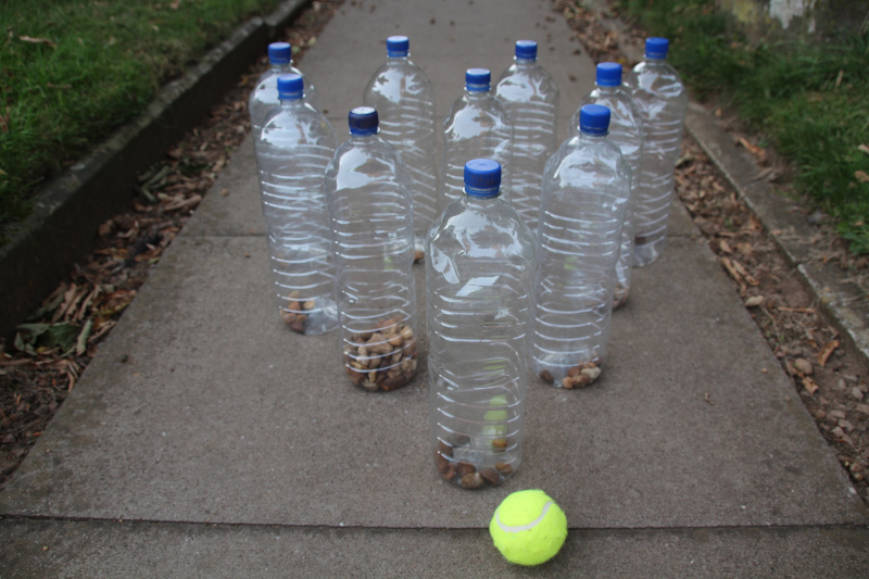 Ball and bottles containing 100 or 10 or 1 pebbles for skittles place value game